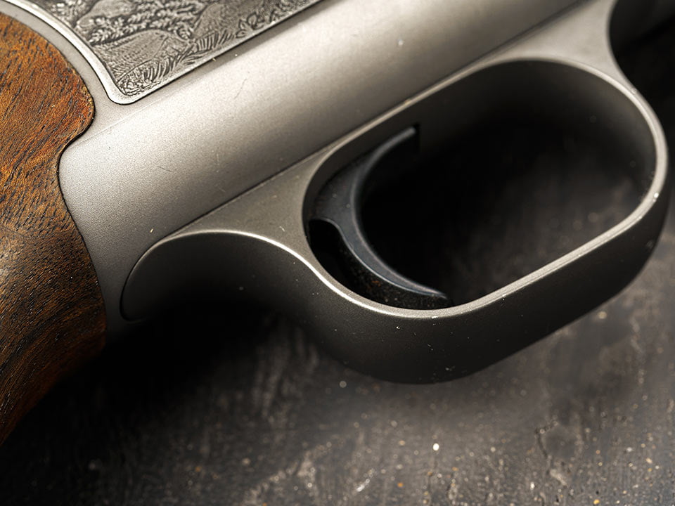 Metal trigger on hunting gun on black background